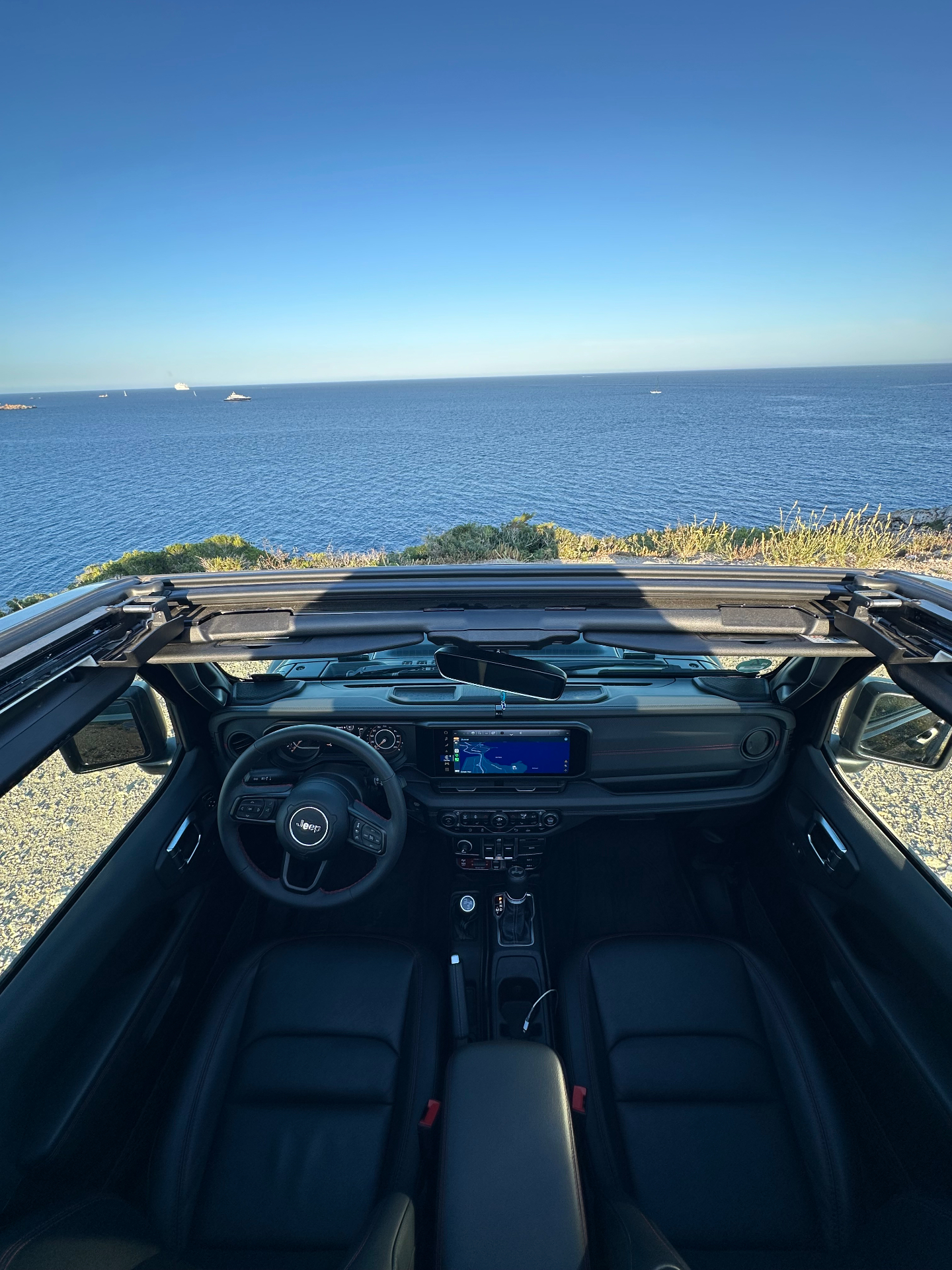 Vista interior del Jeep Wrangler descapotado frente al mar